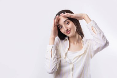 Avuç içi beyaz arka planda, dur hareketi gösteren ciddi bir genç kadının portresi.