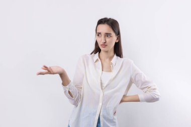 Beyaz arka planda duran şaşırmış yüz ifadesi olan genç ve güzel bir kadın..