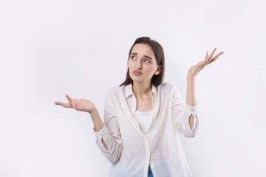 Beyaz arka planda duran şaşırmış yüz ifadesi olan genç ve güzel bir kadın..