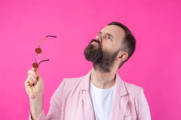 戴胡子的男人穿着粉色夹克 戴着眼镜 情感工作室肖像画 免版税图库图片