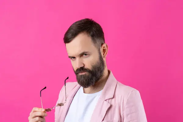 戴胡子的男人穿着粉色夹克 戴着眼镜 情感工作室肖像画 图库照片