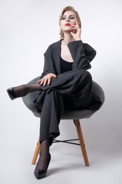 Takım elbiseli, uzun bacaklı iş kadını stüdyoda..