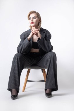 Takım elbiseli, uzun bacaklı iş kadını stüdyoda..
