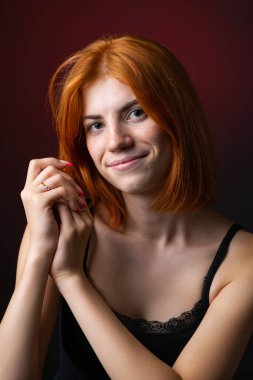 Hoş kızıl saçlı kız, siyah arka planda stüdyo resmi..