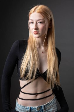 Stüdyoda seksi bluzlu ve kot şortlu sarışın bir kadının portresi..