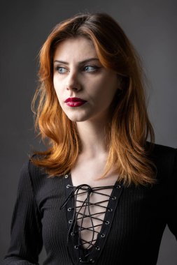 Stüdyoda kasvetli bir geçmişi olan siyah elbiseli kızıl saçlı gotik kız..