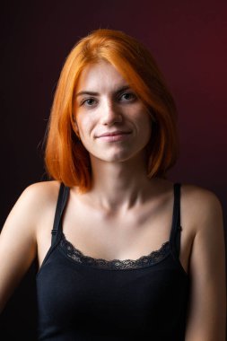 Hoş kızıl saçlı kız, siyah arka planda stüdyo resmi..