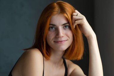 Hoş kızıl saçlı kız, siyah arka planda stüdyo resmi..