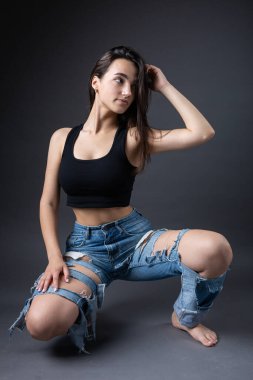 Güzel bir esmer stüdyoda bluz ve kot pantolon giyerek poz veriyor..