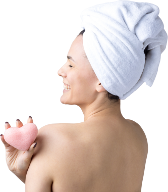 Kafasında beyaz havluyla güzel bir kadın portresi ve pembe bir kalbe bakan bir vücut için sünger. Cilt temizleme eko organik kozmetik rahatlama konsepti.