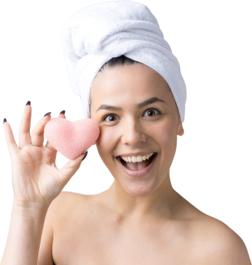 Kafasında beyaz havluyla güzel bir kadın portresi ve pembe bir kalbe bakan bir vücut için sünger. Cilt temizleme eko organik kozmetik rahatlama konsepti.