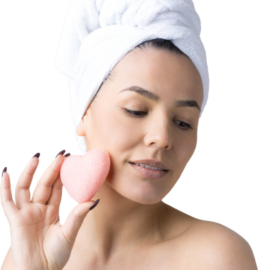 Kafasında beyaz havluyla güzel bir kadın portresi ve pembe bir kalbe bakan bir vücut için sünger. Cilt temizleme eko organik kozmetik rahatlama konsepti.