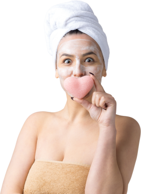 Kafasında beyaz havluyla güzel bir kadın portresi ve pembe bir kalbe bakan bir vücut için sünger. Cilt temizleme eko organik kozmetik rahatlama konsepti.