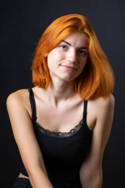 Hoş kızıl saçlı kız, siyah arka planda stüdyo resmi..