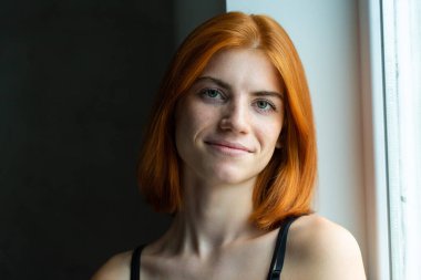 Hoş kızıl saçlı kız, siyah arka planda stüdyo resmi..