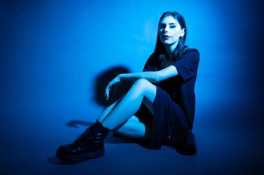 Stüdyoda neon ışıklı bir kızın Gotik tarzı portresi..