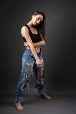 Güzel bir esmer stüdyoda bluz ve kot pantolon giyerek poz veriyor..