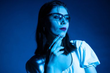 Stüdyoda neon ışıklı bir kızın Gotik tarzı portresi..