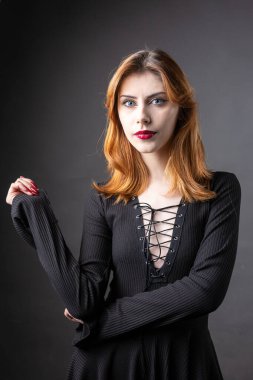Stüdyoda kasvetli bir geçmişi olan siyah elbiseli kızıl saçlı gotik kız..
