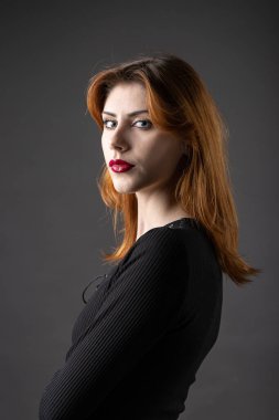 Stüdyoda kasvetli bir geçmişi olan siyah elbiseli kızıl saçlı gotik kız..