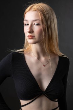 Stüdyoda seksi bluzlu ve kot şortlu sarışın bir kadının portresi..