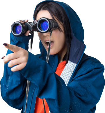 Mavi yağmurluklu bir turist kız elinde dürbünle uzaklığa bakıyor, casuslar..