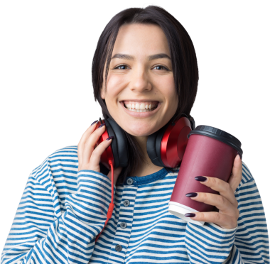 Çizgili yelek giymiş genç bir kız stüdyoda kırmızı kulaklıkla müzik dinliyor ve dans ediyor..