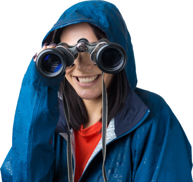 Mavi yağmurluklu bir turist kız elinde dürbünle uzaklığa bakıyor, casuslar..