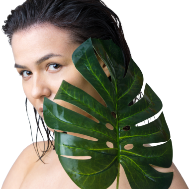 Doğal yeşil palmiye yaprağı portresi olan bir kadın. Moda, güzellik, makyaj, kozmetik.