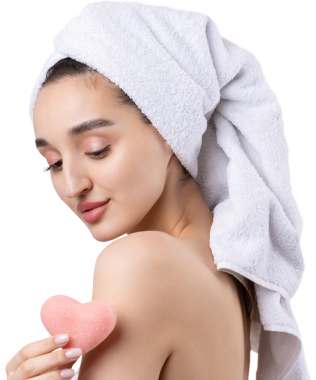 Kalın kaşlı güzel bir kız, beyaz arka planda mükemmel bir ten, kafasında havlu, güzel bir fotoğraf. Kozmetik pembe bir kalp süngeri tutuyorum..