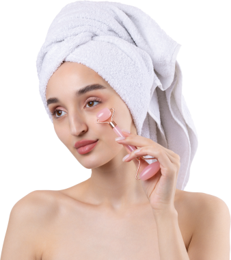 Kalın kaşlı güzel bir kız, beyaz arka planda mükemmel bir ten, kafasında havlu, güzel bir fotoğraf. Kozmetik rulo tutuyor..