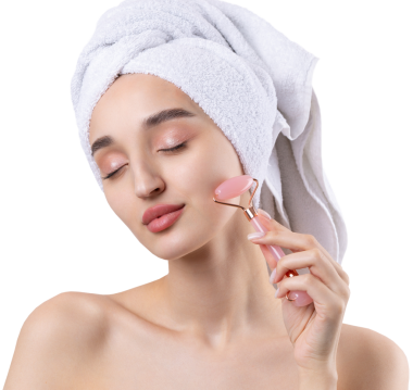 Kalın kaşlı güzel bir kız, beyaz arka planda mükemmel bir ten, kafasında havlu, güzel bir fotoğraf. Kozmetik rulo tutuyor..