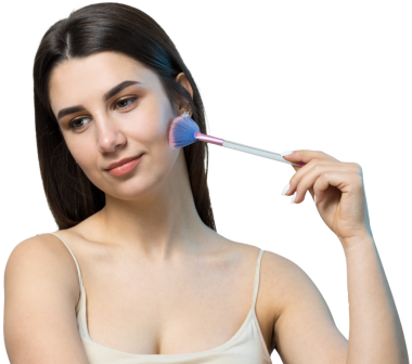 Açık renk bluzlu, beyaz arka planda yüz makyajı yapan genç bir kızın yakın çekimi. Güzel bir kadın yüzüne bir makyaj fırçası tutar ve gülümser..