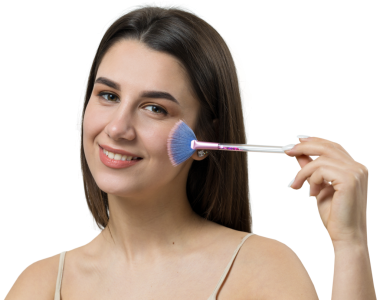 Açık renk bluzlu, beyaz arka planda yüz makyajı yapan genç bir kızın yakın çekimi. Güzel bir kadın yüzüne bir makyaj fırçası tutar ve gülümser..