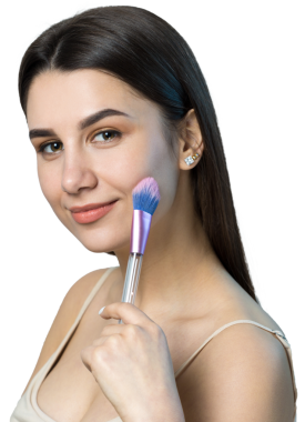 Açık renk bluzlu, beyaz arka planda yüz makyajı yapan genç bir kızın yakın çekimi. Güzel bir kadın yüzüne bir makyaj fırçası tutar ve gülümser..