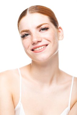 Beyaz bluzlu, kızıl saçlı, çilli genç bir kız. Stüdyoda beyaz arka planda bir kadının güzel portresi..