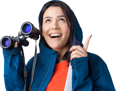 Mavi yağmurluklu bir turist kız elinde dürbünle uzaklığa bakıyor, casuslar..