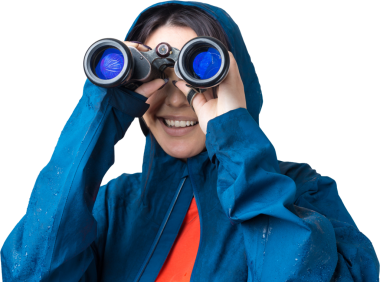 Mavi yağmurluklu bir turist kız elinde dürbünle uzaklığa bakıyor, casuslar..