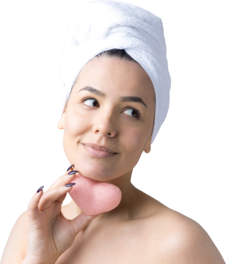 Kafasında beyaz havluyla güzel bir kadın portresi ve pembe bir kalbe bakan bir vücut için sünger. Cilt temizleme eko organik kozmetik rahatlama konsepti.