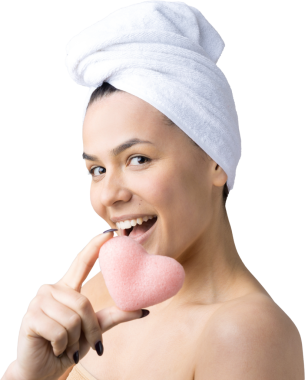 Kafasında beyaz havluyla güzel bir kadın portresi ve pembe bir kalbe bakan bir vücut için sünger. Cilt temizleme eko organik kozmetik rahatlama konsepti.