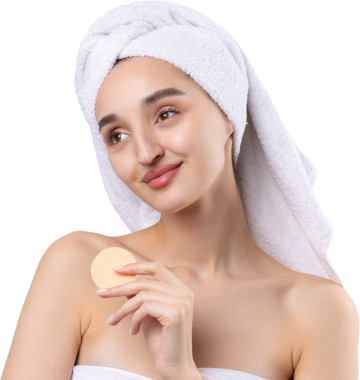 Kalın kaşlı güzel bir kız, beyaz arka planda mükemmel bir ten, kafasında havlu, güzel bir fotoğraf. Kozmetik sünger tutuyor..