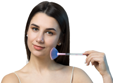 Açık renk bluzlu, beyaz arka planda yüz makyajı yapan genç bir kızın yakın çekimi. Güzel bir kadın yüzüne bir makyaj fırçası tutar ve gülümser..