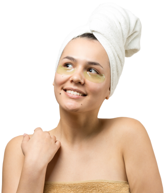 Kafasında beyaz havluyla gezen genç bir kız gözlerinin altına kolajen jel bantlar takıyor. Göz teması altında maske.