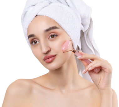 Kalın kaşlı güzel bir kız, beyaz arka planda mükemmel bir ten, kafasında havlu, güzel bir fotoğraf. Kozmetik rulo tutuyor..