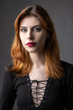 Stüdyoda kasvetli bir geçmişi olan siyah elbiseli kızıl saçlı gotik kız..