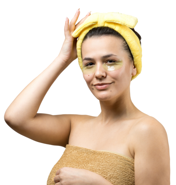 Kafasında beyaz havluyla gezen genç bir kız gözlerinin altına kolajen jel bantlar takıyor. Göz teması altında maske.