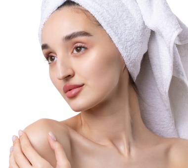 Kalın kaşlı güzel bir kız, beyaz arka planda mükemmel bir ten, kafasında havlu, güzel bir fotoğraf..