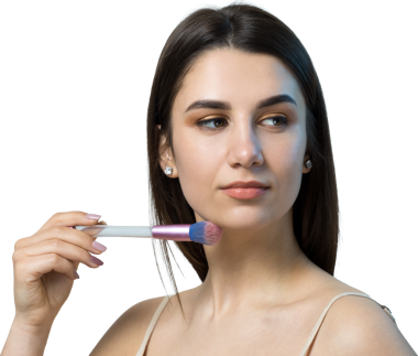 Açık renk bluzlu, beyaz arka planda yüz makyajı yapan genç bir kızın yakın çekimi. Güzel bir kadın yüzüne bir makyaj fırçası tutar ve gülümser..