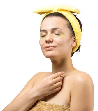 Kafasında beyaz havluyla gezen genç bir kız gözlerinin altına kolajen jel bantlar takıyor. Göz teması altında maske.