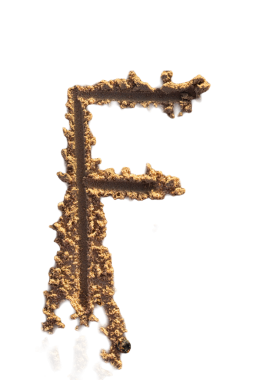 Alfabe (F) harfleri kumsalda el yazısıyla yazılmış.